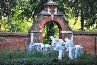  ?? Ben Stansall / AFP via Getty Images ?? Forensics officers dressed in protective suits search the entrance to the park in the city of Reading where three people were killed and three others were injured in a stabbing attack.