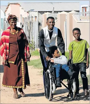  ?? Picture: FREDLIN ADRIAAN ?? NEW LEASE ON LIFE: Asanda Mazele, 11, of New Brighton, tries out the wheelchair she received with the assistance of local social worker Thembelani Lesman, centre, and church groups. With them are Asanda’s mother, Nontsikele­lo, and twin brother, Ayanda