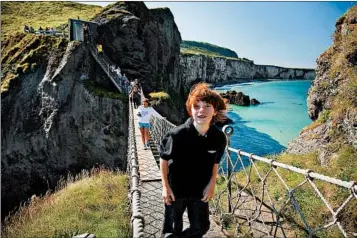  ?? DOMINIC ARIZONA BONUCCELLI/RICK STEVES’ EUROPE ?? Get your ticket to cross Northern Ireland’s ramshackle Carrick-a-Rede Rope Bridge along the Antrim Coast first thing in the morning, before the cruise groups — and the wind — take over. Tickets are only sold in person, on the same day.