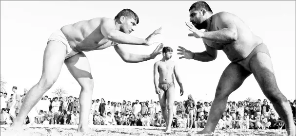  ?? — AFP photos ?? Pakistani immigrant workers in the United Arab Emirates take part in a Kushti competitio­n in Dubai. Kushti is popular in India, Pakistan and Bangladesh and was developed in the Mughal era by combining native ‘malla-yuddha’ wrestling with Persian...