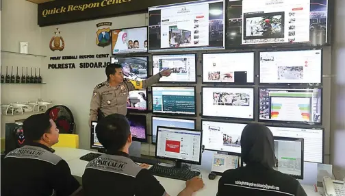  ?? BOY SLAMET/JAWA POS ?? STAND BY: Kabag Ops Polresta Sidoarjo Kompol Edi Santoso memantau posting-an warga di media sosial di quick response center kemarin.