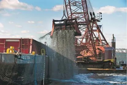  ?? KENNETH K. LAM/BALTIMORE SUN ?? A dredge dumps muck from the Seagirt Channel West on Wednesday into a waiting barge. The channel and the Fort McHenry Channel are being dredged under a $25.6 million contract awarded by the U.S. Army Corps of Engineers. The project will remove...