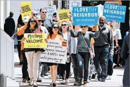  ?? STEVE HELBER/AP ?? Protesters voice their opposition to President Trump’s revised travel ban this month outside the 4th Circuit in Richmond, Va. The court ruled 10-3 Thursday to uphold the freeze.