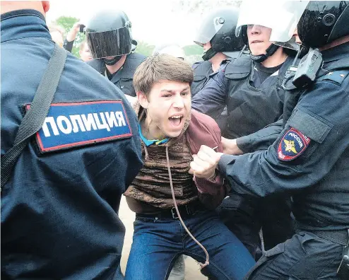  ?? OLGA MALTSEVA / AFP / GETTY IMAGES ?? Russian police officers detain a young protester at an opposition rally in Saint Petersburg on Monday.