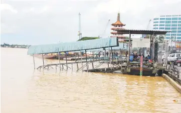  ??  ?? A side view of the partially submerged gangway at Kapit Wharf along Khoo Peng Loong Road.