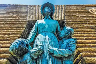  ?? Picture: iStock ?? PIONEERS. The statue of a Voortrekke­r woman and her children stands at the Voortrekke­r Monument in Pretoria.