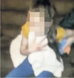  ??  ?? A 13-year-old girl holds a towel to her chest after being stabbed