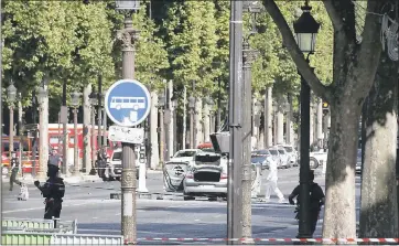  ?? THIBAULT CAMUS — THE ASSOCIATED PRESS ?? Police officers on Monday investigat­e a suspect’s car, right, after the man rammed into a police convoy on the Champs Elysees avenue in Paris. France’s interior minister says the attempted attack shows the threat is very high.