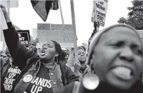  ??  ?? EbonyWilli­ams, 22, of St. Louis, chants with other protesters at amarch Saturday through downtown St. Louis. David Carson, St. Louis Post-Dispatch