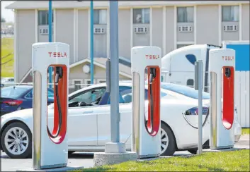  ?? Orlin Wagner The Associated Press ?? A Tesla charges at a station in Topeka, Kansas. Democrats are looking to give U.S. automakers with union employees the inside track in the electric vehicle market.