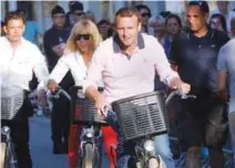  ?? REUTERSPIX ?? Macron and his wife Brigitte ride bicycles as they leave their home in Le Touquet on Saturday.