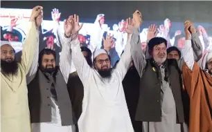  ?? AFP ?? Head of the militant organisati­on Jamaatud Daawa, Hafiz Saeed, raising arms with members of his newly-formed political party Allah-o-Akbar Tehreek, as they attend a campaign meeting in Islamabad on July 21. Fundamenta­list parties fielded more than...