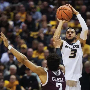  ?? AP/L.G. PATTERSON ?? Missouri senior guard Kassius Robertson (right) shoots over Texas A&M’s Admon Gilder during the second half Feb. 13 in Columbia, Mo. Robertson, along with fellow senior Jordan Barnett, will be honored before today’s game against Arkansas.
