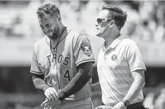  ?? Kyusung Gong / Associated Press ?? The Astros’ George Springer, left, exits with a trainer after getting injured Sunday.