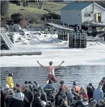 ?? DARREN CALABRESE/THE CANADIAN PRESS ?? A man jumps off a wharf into the Atlantic Ocean as hundreds gathered for the Herring Cove Polar Bear Dip in Herring Cove, N.S., on Monday.