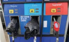  ?? — Reuters ?? Two out of service fuel nozzles are covered in plastic on a gas pump at a gas station in Waynesvill­e, North Carolina.