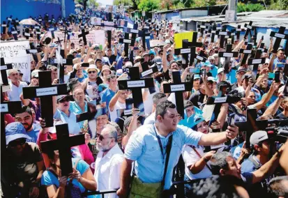  ?? FOTO AFP ?? Simpatizan­tes del presidente de El Salvador, Nayib Bukele, marcharon por las calles de la capital enarboland­o cruces con los nombres de legislador­es opositores.