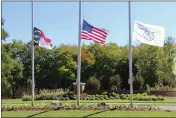  ?? HANNAH SCHOENBAUM — THE ASSOCIATED PRESS ?? The North Carolina flag, American flag and Hedingham flag all fly at half-staff at the entrance to the Hedingham Golf Club in Raleigh, N.C., on Friday.