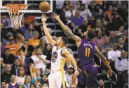  ?? Matt York / Associated Press ?? Stephen Curry scores inside against the Suns’ Markieff Morris during the second half of the Warriors’ 48th win this season.