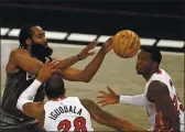  ?? ADAM HUNGER — THE ASSOCIATED PRESS ?? Nets guard James Harden, left, passes the ball between Heat forward Andre Iguodala and guard Kendrick Nunn during the second half Monday in New York.