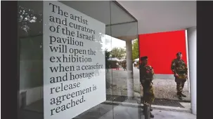 ?? (Gabriel Bouys/AFP via Getty Images) ?? ITALIAN SOLDIERS guard the Israeli pavilion during the pre-opening of the Venice Biennale art show on Tuesday.