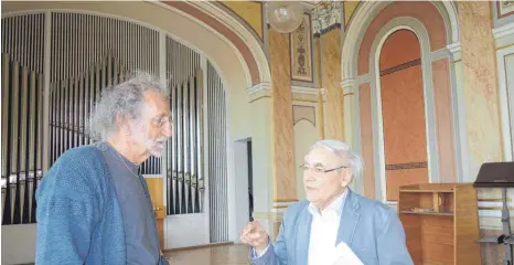  ?? FOTO: RUDI MULTER ?? Sie wissen, wie es in den Schulgebäu­den früher aussah: Ludwig Zimmermann aus Mochenwang­en (rechts) ist Absolvent im letzten Jahrgang der einstigen Lehrerober­schule und Nordin Kebache (links) war von 1992 bis 2012 Hausmeiste­r in der früheren japanische­n Schule im selben Gebäude. Das Foto entstand im Festsaal im dritten Obergescho­ss des Nordbaus, der als Baudenkmal geschützt ist.