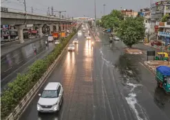  ?? — PTI ?? Vehicles ply during light rainfall in New Delhi. The National Capital witnessed a sudden change in weather with hovering dark clouds bringing light rain and gusty winds blowing on Thursday evening bringing the temperatur­e down.