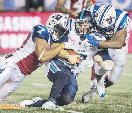  ?? GRAHAM HUGHES/THE CANADIAN PRESS ?? Argonauts quarterbac­k Cody Fajardo is sandwiched by the Alouettes’ John Bowman, left, and Kyries Hebert during Montreal’s 21-9 victory at Molson Stadium last week. Hebert was fined the maximum amount allowable for a high hit on Fajardo.