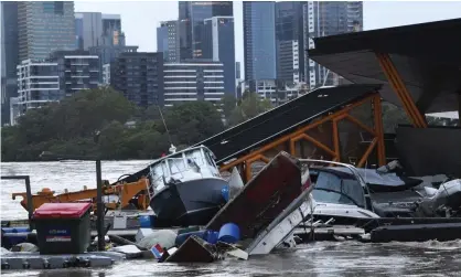  ?? Photograph: Darren England/AAP ?? Boats and other debris washed into the Milton ferry terminal on the Brisbane River on Monday, where flood water is inundating homes.