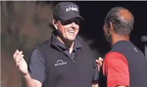  ??  ?? Phil Mickelson (left) shakes hands with Tiger Woods (right) after The Match: Tiger vs. Phil golf match at Shadow Creek Golf Course.