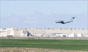  ?? Myung J. Chun Los Angeles Times ?? A BOEING C-17 Globemaste­r III lands at L.A./Palmdale Regional Airport during exercise f lights this month. Northrop Grumman, background, was awarded the B-21 bomber contract in October 2015.