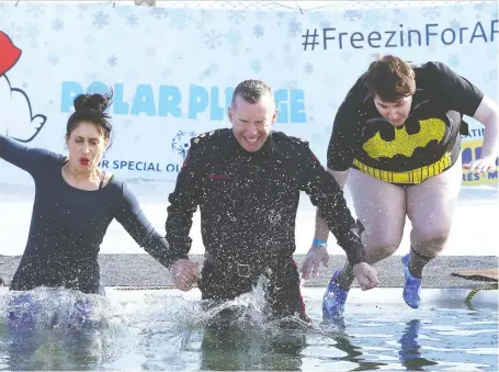  ?? JIM WELLS ?? Alberta Minister of Culture Leela Aheer, left, and Calgary Police Chief Mark Neufeld, centre, lead the participan­ts in the Polar Plunge Freezin for a Reason to raise funds for Special Olympics at Arbour Lake in northwest Calgary on Saturday.