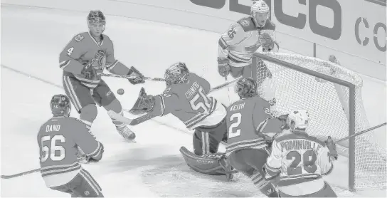  ?? | CHARLES REX ARBOGAST/AP ?? Marko Dano (56), Niklas Hjalmarsso­n (4) and Duncan Keith (2) have front-row seats as the Hawks’ Corey Crawford stretches to make a save Tuesday.