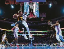  ?? ?? The Hawks’ Trae Young (11) passes against the 76ers’ Joel Embiid (21) during the second half.