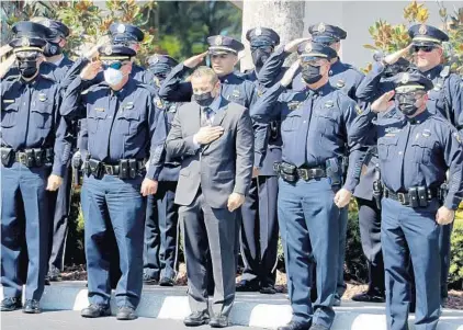  ?? MIKE STOCKER/SOUTH FLORIDA SUN SENTINEL ?? Police brass, including new chief Larry Scirotto, center in the suit, salute as the funeral procession for Fort Lauderdale police officer Jennifer Sepot arrives at the Abundant Life Church in Margate on Friday.