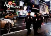  ?? EDUARDO MUNOZ / REUTERS ?? Police officers walk around Times Square ahead of New Year's Eve celebratio­ns in New York on Saturday.