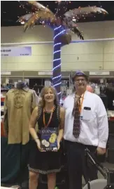  ??  ?? There’s a lot of things dealers can do to draw visitors to their booths and tables, and for some that include incorporat­ing some extensive decoration­s like tropical theme, like Steve Cairns, pictured here with COINage’s Tracy Alvarez, and his team of Honor Coin & Stamp chose to do during the FUN Convention.