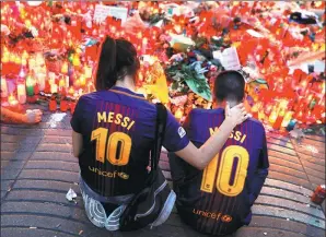  ?? SUSANA VERA / REUTERS ?? People gather at an impromptu memorial for those killed in a terrorist attack at Las Ramblas in Barcelona on Sunday.