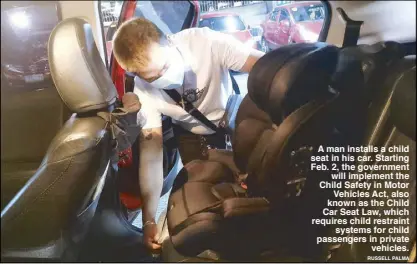  ?? RuSSeLL PALMA ?? A man installs a child seat in his car. Starting Feb. 2, the government will implement the Child Safety in Motor Vehicles Act, also known as the Child Car Seat Law, which requires child restraint systems for child passengers in private vehicles.