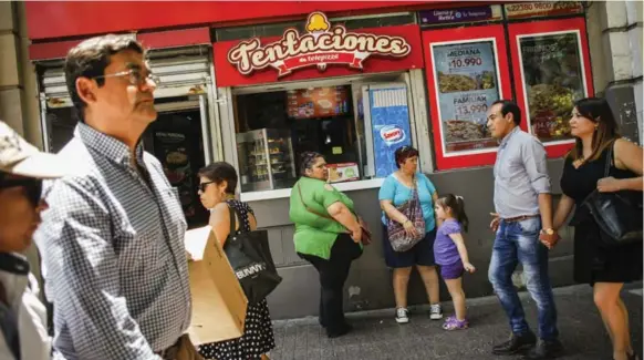  ?? VICTOR RUIZ CABALLERO PHOTOS/THE NEW YORK TIMES ?? Customers at the window of a fast food pizza-maker in Santiago, Chile. Facing skyrocketi­ng rates of obesity, the government is using marketing restrictio­ns to wage war on unhealthy foods.