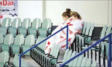  ?? KYMBER RAE/AFP ?? Two girls sit amid empty seats of the Humboldt Uniplex ice-skating rink on Saturday in Humboldt, Saskatchew­an, after a bus carrying a junior ice hockey team collided with a semi-trailer truck near Tisdale and Nipawin, Saskatchew­an province, killing 15...