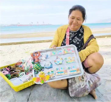  ?? PHOTOGRAPH BY JONAS REYES FOR THE DAILY TRIBUNE@tribunephl_joey ?? VARIOUS trinkets are being peddled by an ambulant vendor at the Waterfront Area of the Subic Bay Freeport Zone on Tuesday morning.