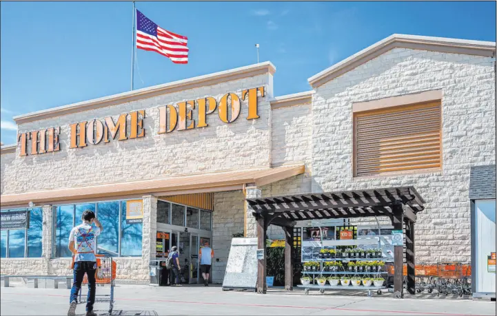  ?? Brandon Bell Tribune News Service ?? An employee returns a cart at a Home Depot store in February in Austin, Texas. The company is acquiring a leading constructi­on materials distributo­r for $18.25 billion.