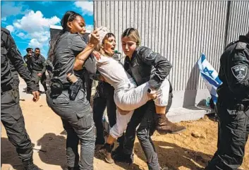  ?? Marcus Yam Los Angeles Times ?? ISRAELI SECURITY forces apprehend one of the right-wing activists trying to block aid shipments from getting into the Gaza Strip in Kerem Shalom, Israel, on March 7.