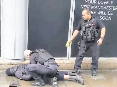  ?? PHOTO: REUTERS ?? Detained: A police officer points a Taser while the other holds a man down outside Arndale shopping centre. Below: An armed officer stands guard.