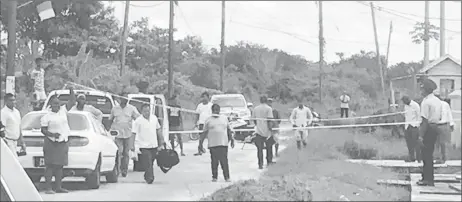  ??  ?? Investigat­ors and onlookers at the scene of the murder yesterday morning.