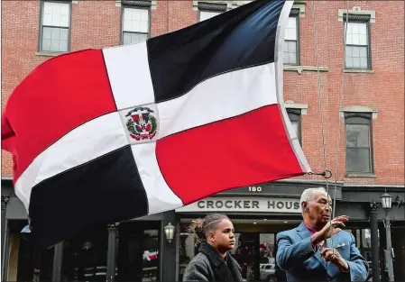  ?? SARAH GORDON/THE DAY ?? Juan Jimenez, right, raises the Dominican Republic flag with help from Jeffrey Zapata, 13, as the Asociación de Dominicano­s de New London celebrates the independen­ce of the Dominican Republic outside New London City Hall on Sunday. Today is the 179th anniversar­y of the country’s independen­ce from Haiti.