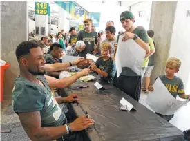  ?? ROD AYDELOTTE/WACO TRIBUNE HERALD, VIA AP ?? Baylor running back Shock Linewood shares a laugh Aug. 6 while meeting fans during the annual “Meet the Bears” event at McLane Stadium in Waco, Texas.
