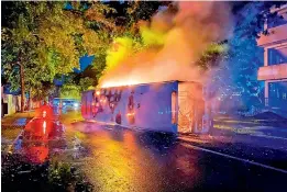  ?? — AFP ?? A bus burns close to Sri Lanka’s ex-Prime Minister Mahinda Rajapaksa’s official residence, in Colombo on Monday.