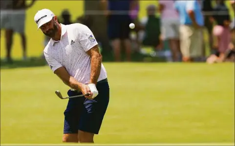  ?? Matt York / Associated Press ?? Dustin Johnson chips to the green on the first hole during a practice round for the PGA Championsh­ip on Wednesday in Tulsa, Okla.